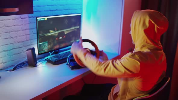 Young man playing car racing. Male gamer playing racing game on computer