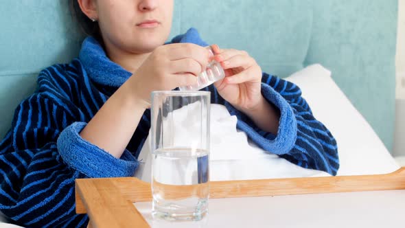 Closeup  Footage of Young Woman Feeling Sick Lying in Bed and Drinking Pills