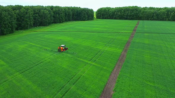 Drone View of Tractor Fertilizing Green Agricultural Field.