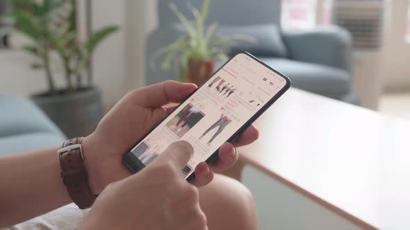 Close Up Of Man Hand Holding Smartphone And Doing Online Shopping At Home