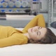 Happy Young Woman Enjoying Lying on New Mattress at Furniture Store - VideoHive Item for Sale