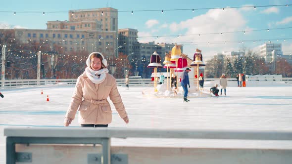 Young Smiling Woman Ice Skating Outside on Ice Rink Central City Square at Christmas Holiday Active