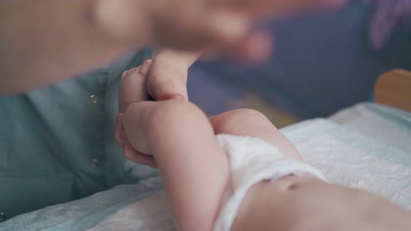 Pediatrician Rubs and Massages Adorable Infant Legs