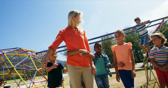 Trainer and schoolkids having fun in playground