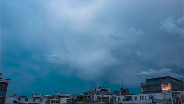 Time lapse of fast moving storm clouds over apartment buildings and residential buildings. The cloud
