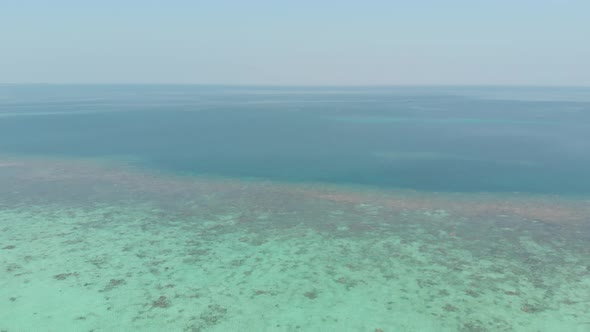 Aerial: flying over desert tropical beach in the Moluccas archipelago, Indonesia