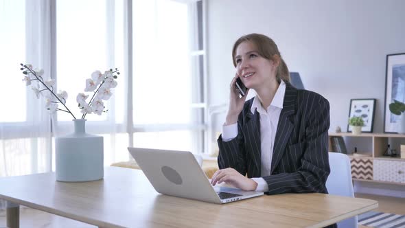 Young Woman Attending Call at Work Talking on Phone