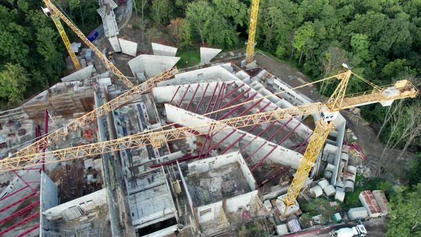 Aerial View Construction of a New Building with High Tower Cranes in Green Area