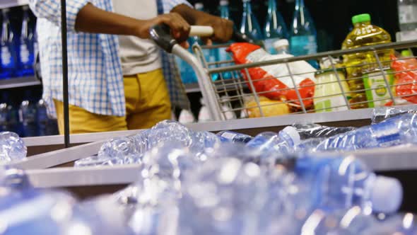 Man buying bottle of water at grocery section