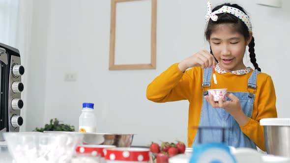 Pretty Asian girl baking homemade bakery cup cake.