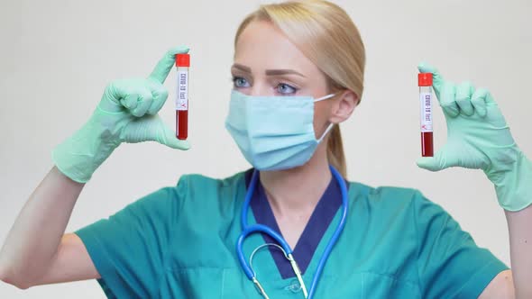 Medical Doctor Nurse Woman Wearing Protective Mask and Latex Gloves - Holding Blood Test Tube