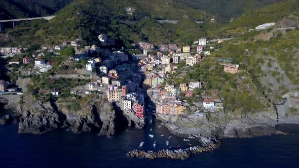 Riomaggiore Cinque Terre Italian coastline with residential buildings on the cliffside, Aerial dolly