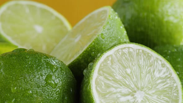 Green Limes Isolated on Yellow Background Fresh and Ripe Citrus Fruits