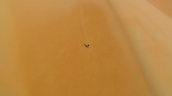 Aerial view of a man walking on dunes during the sunset, U.A.E.