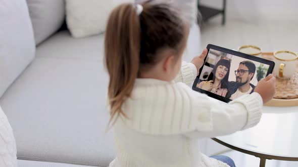 Young Girl Sitting and Relaxing on Sofa at Home and Talking on Video Call with Smiling Mother and