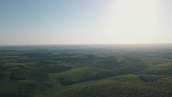 Drone Flight View Above Green Forest And Agricultural Land Landscape at Sunset