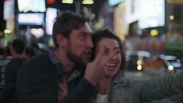 Couple taking selfie in Times Square, New York City, New York