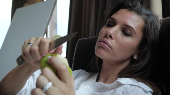 a Woman with a Beautiful Manicure Cuts an Apple with a Knife