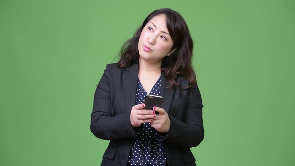 Mature Beautiful Asian Businesswoman Thinking While Using Phone