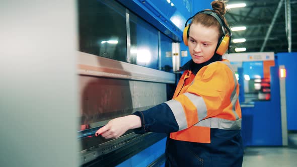 Female Engineer is Operating a Metalbending Machine