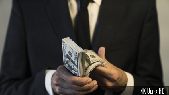 4K Businessman Holding and Counting American $100 Dollar Banknotes for Money and Financial Concept