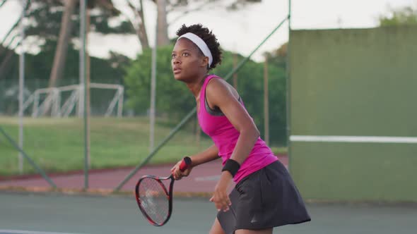 Video of focused african american female tennis player holding racket and hitting ball