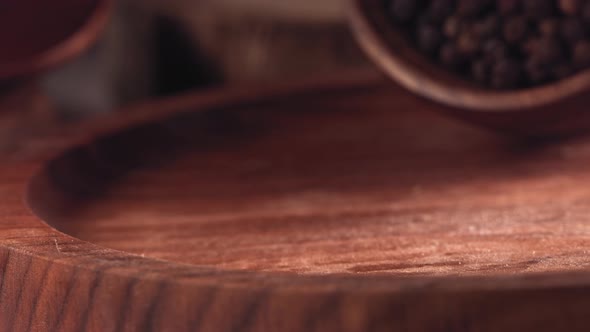 Black Pepper Falling on a Wooden Table