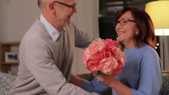 Happy Senior Couple with Bunch of Flowers at Home