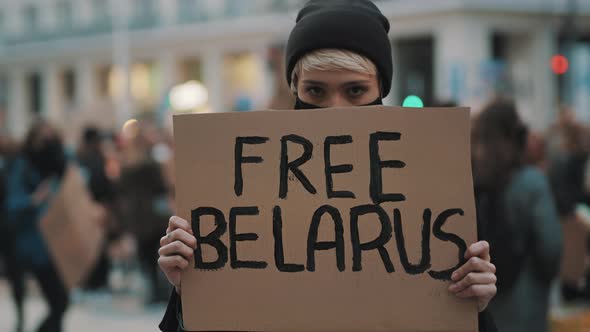 Young Woman with Face Mask Holding Banner with Writtings - Free Belarus