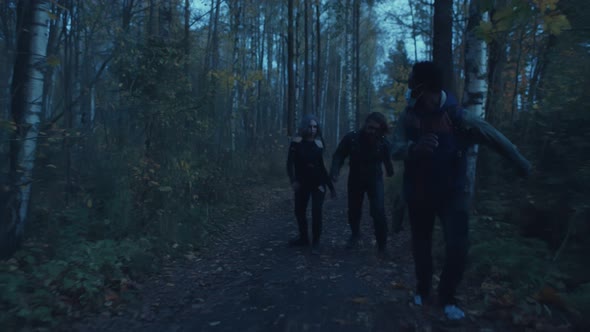 Zombie Couple Chasing African Man in Safety Mask in Twilight Woods