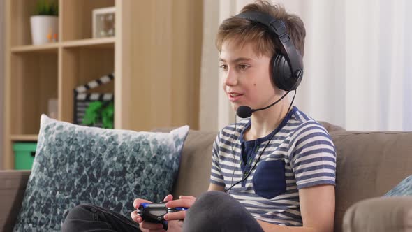 Boy with Gamepad Playing Video Game at Home