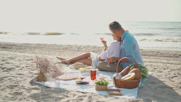 Affectionate Young Family Couple Happy Husband and Wife Sit on Cozy Picnic Blanket with Wine Fruits