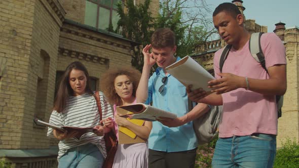 Mixed Race Students Discussing Topic While Walking Outdoors at Sunset