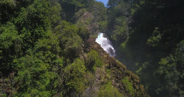 Drone image panning over a waterfall where you can see from the base to where the waterfall is born.