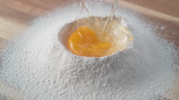Egg falls on a pile of flour. Slow Motion. alt