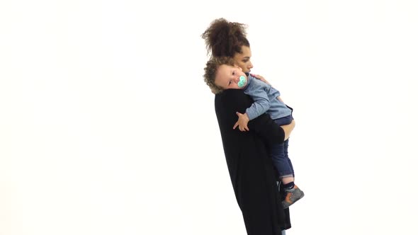 Girl Is Holding the Baby, He Has a Nipple, He Was Crying. White Background. Slow Motion