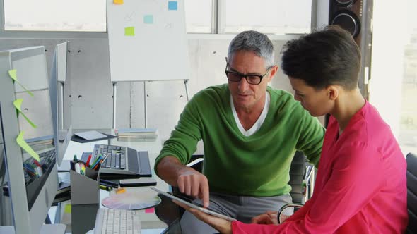 Caucasian Business people discussing over digital tablet at desk in office 4k