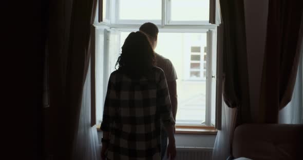 Young Couple Man and Woman Stay Near Window at Home
