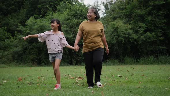 Grandmother with granddaughter walking talk about family in the park