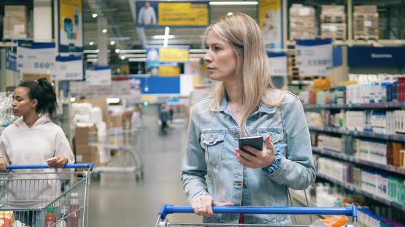 Women are Walking Along the Store Aisle with Travel Dishware