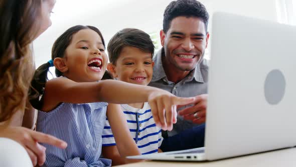 Happy family using laptop in living room