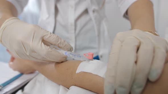 Doctor Putting a Drip Into the Catheter Lying Patients close-up.Injection Vaccine.