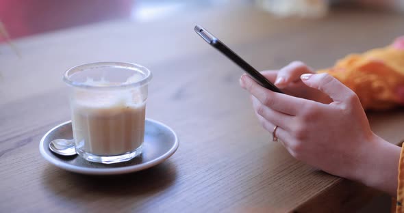 Woman Hands Using Smart Phone Sitting in a Cafe