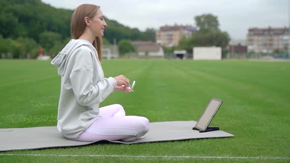 Young athletic girl preparing for online training by video call