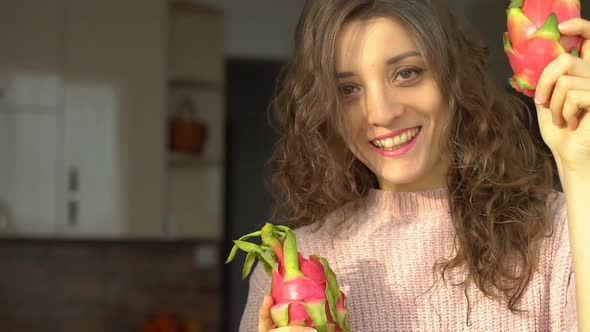 Young Girl is Holding Two Fresh Ripe Organic Dragon Fruits or Pitaya Pitahaya