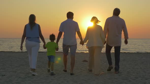 Family Looking at Golden Sunset Over the Sea