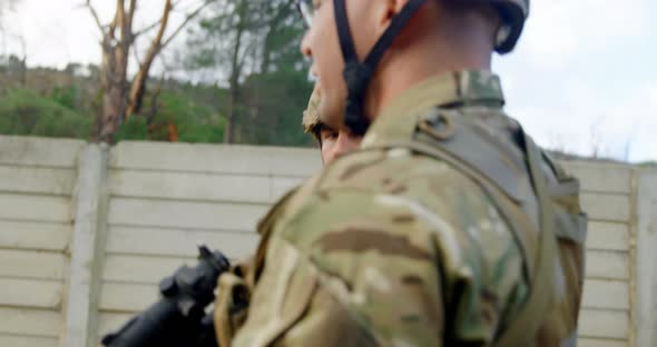 Side view of caucasian military soldiers rifle training in fields during military training 4k