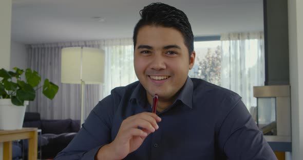 Young man happily smiles in the camera.