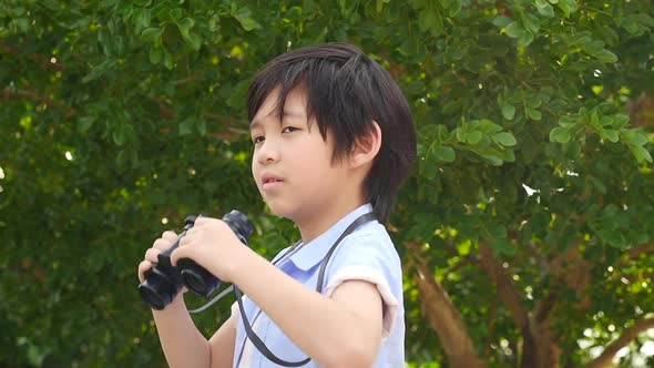 Cute Asian Child Using Binocular On Summer Day