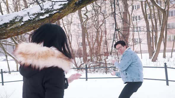 Young Happy Asian Couple Playing Winter Games